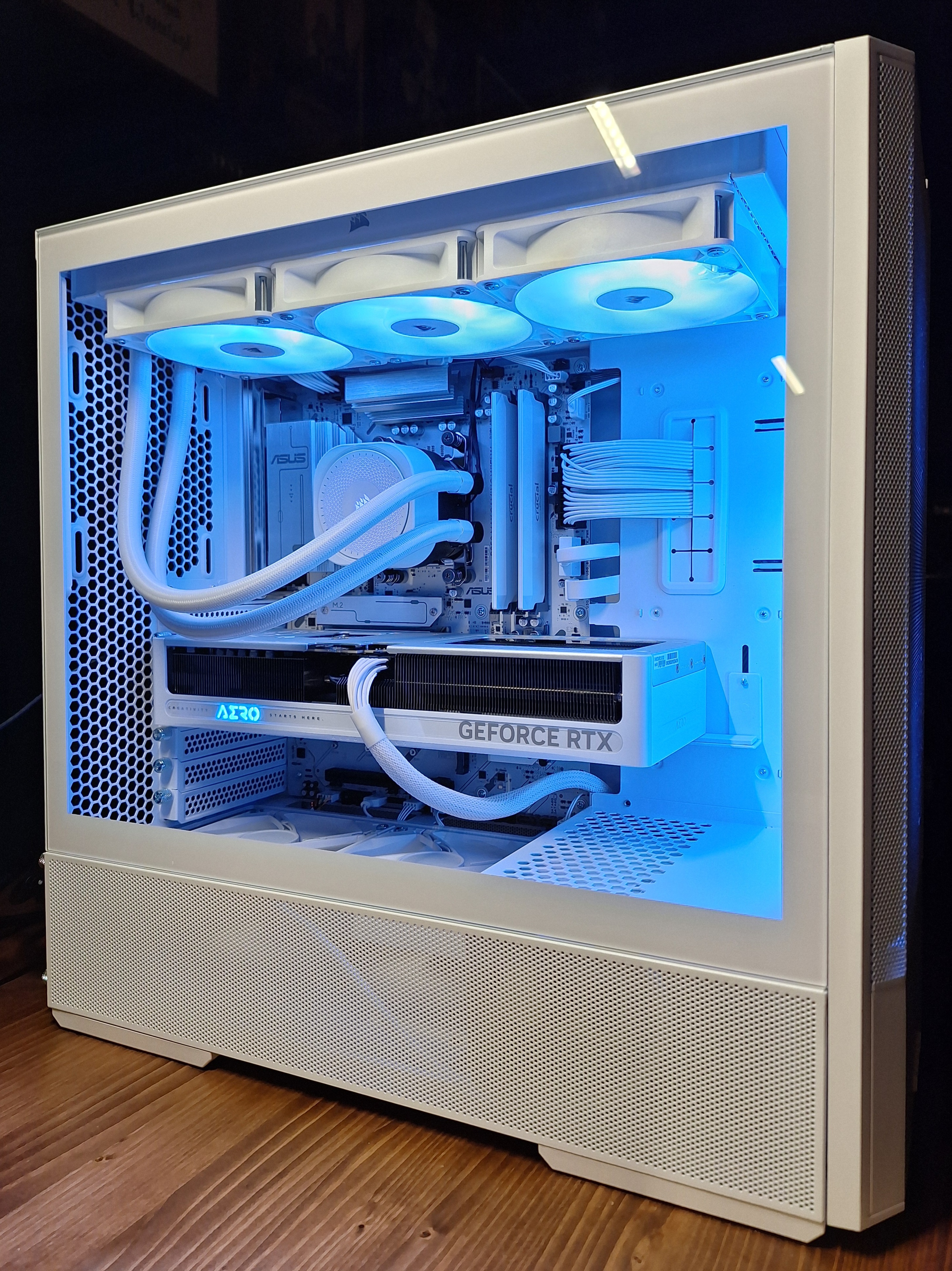 Completed white Lancool 207 gaming PC with blue interior lighting viewed from the side